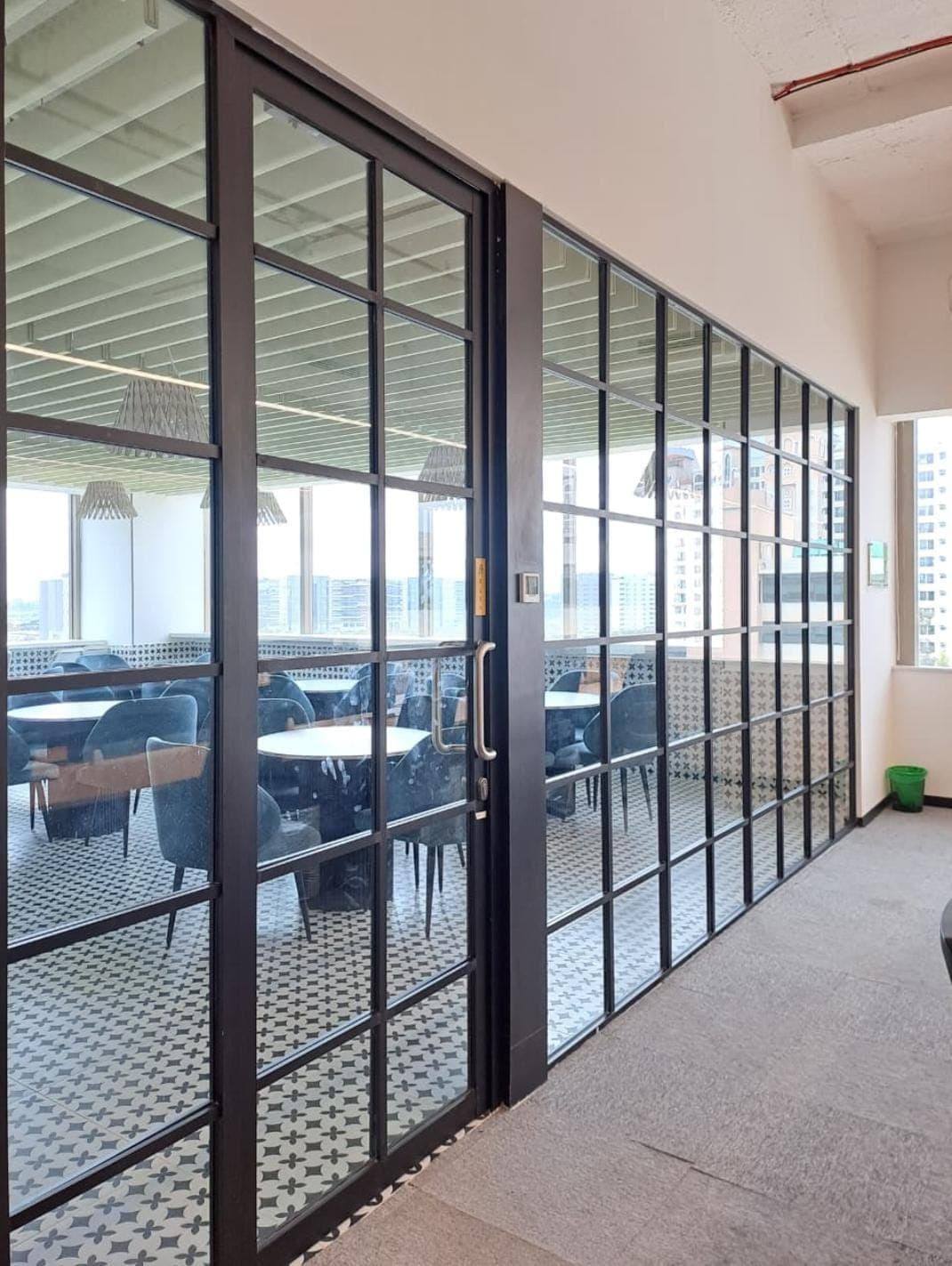 Glass cabin partition with a hinged door in an office
