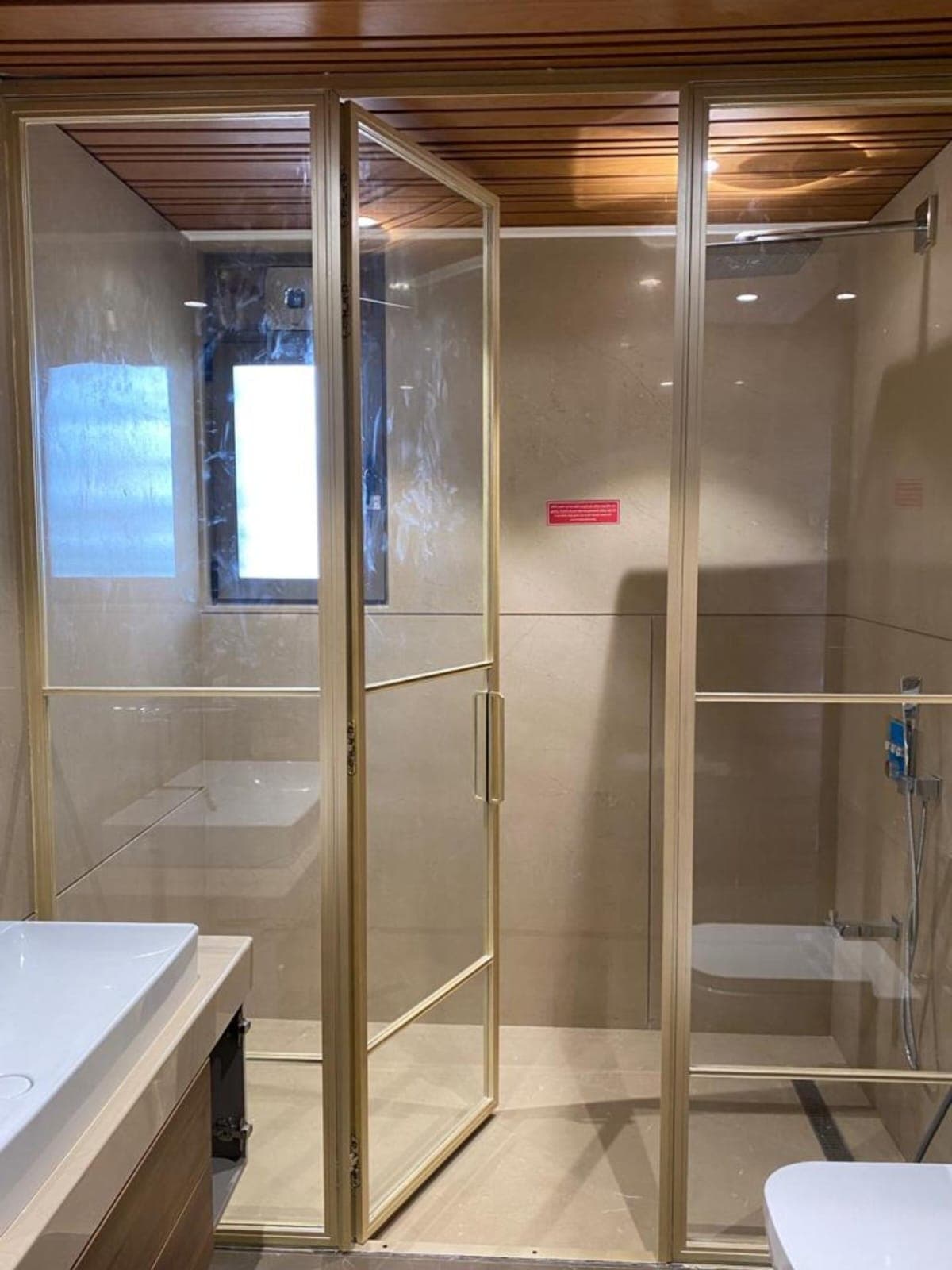Wall-to-wall frameless shower screen in clear toughened glass